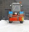 Short break in work on snow cleaning. Snowplow near wall