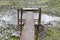 A short footbridge over a drained pond