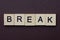 Short gray word break made of wooden square letters
