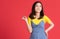 Short hair asian woman Looks cute and bright. Pointing finger Select an option On a red background In ideas for advertising