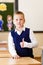 Short-haired eight-year-old handsome schoolboy stands in class in school uniform