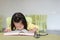 Short sighted little child girl reading a book in the kids room