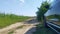 A short stop during a summer road trip. The car is parked on the side of a country road next to a paved highway. There is a cornfi