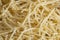 Short thin vermicelli on the whole background. texture of dry yellow pasta