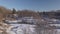 Short video rising up from behind trees covered of white snow near the frozen river