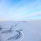 Short winter day above frozen tundra river, top view