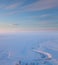 Short winter day above frozen tundra river, top view