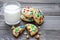 Shortbread cookies with multi-colored candy and chocolate chips, served with glass of milk, horizontal