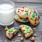 Shortbread cookies with multi colored candy and chocolate chips, served with glass of milk, square