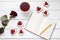 Shortbread heart shaped cookies with empty notebook, pencil, cup of tea and rose flower on white wooden background for