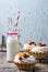 Shortbread tartlets with fruits, berries and cream protein with milk on a rustic wooden background