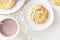 Shortbread whipped nuts cookies on white plate. White wooden background. Copy space. Close up. Top view