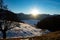 Shortly before sunset: Snow covered alpine meadows and a valley in the fog