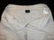 Shorts beige, front side unbuttoned, with labels, on black background