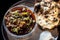 Shot of Achari Chicken along with tandoori roti with it on a serving plate with some chilies, onions, and lemons.