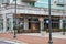 A shot of the Allora italian restaurant with lush green plants and tall black light posts in front at Atlantic Station in Atlanta