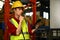 Shot of Asian male worker in safety uniform working in warehouse full of tall shelves with goods