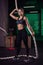 Shot of an attractive female crossfit athlete with a rope at the gym.