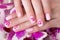 Shot beautiful manicure with flowers on female fingers. Nails design. Close-up