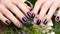 Shot beautiful manicure with flowers on female fingers. Nails design. Close-up