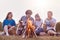 Shot of best female and male friends enjoy summer day on picnic, play acoustic guitar, sit near campfire, have romantic atmosphere