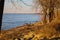 A shot of the blue running waters of the Mississippi river with people on the banks with bare trees and yellow grass