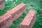 Shot of bricks placed in high ordered piles on grass ready for the construction of property, real estate, offices, homes