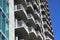 A shot of a buildings with rows of balconies with gray metal rails and glass windows with blue sky in downtown Atlanta