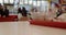 Shot of a busy cafe in a mall, people are all blurred. Defocused food court and table top with litter on foreground.