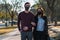 Shot of a couple with masks walking in a park - the new normal concept