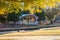 A shot of a curvy white amphitheater in the park surrounded by gorgeous autumn colored trees near a lake