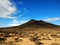 Shot of a dry wasteland and a mountain in the distance in Corralejo Natural Park, Spain