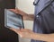 Shot of the female doctor in uniform against the white wall studying x-ray image of the lungs on the tablet. Healthcare