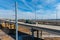 A shot of a freeway filled with cars and Semi trucks and tall power line poles along the highway with yellow winter grass