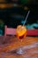 Shot of fresh summer cocktail with orange and ice in wine glass. Aperol spiritz cocktail in bar with no people. Blurred background