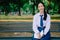 Shot of a girl college student sitting reading book on a bench in the park