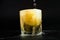 Shot of golden Mexican tequila with lime and salt on black background. A glass of tequila with lemon slices and splashing.