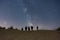 Shot of a group of people looking at the starry night through telescopes on top of a sandy hill