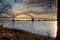 A shot of the Hernando de Soto Bridge over the flowing waters of the Mississippi river with a blue sky at sunset