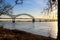 A shot of the Hernando de Soto Bridge over the flowing waters of the Mississippi river with a blue sky at sunset