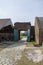 A shot of the large arched doorway with green doors and a stone footpath on a cloudy day at Old Fort Jackson in Savannah Georgia