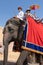 Shot of line of elephants covered in red cloth with tourists riding on them to the landmark hill fort of Amber in Jaipur