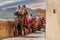 Shot of line of elephants covered in red cloth with tourists riding on them to the landmark hill fort of Amber in Jaipur