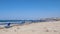 Shot of the lonely sandy beach with sunbed on the stormy windy day. Strong waves hitting and splashing against the seashore. Slowm