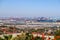 A shot of the Long Beach harbor with blue harbor cranes and ships with shipping containers sitting off the coast