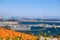 A shot of the Long Beach harbor with blue harbor cranes and ships with shipping containers sitting off the coast