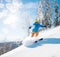 Shot of a male freerider skiing in the mountains on fresh powder snow on sunny winter day