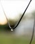 Shot of a metal wire, with water droplets suspended from its surface