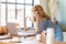 Shot of middle aged woman using mobile phone and laptop while working from home