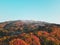 Shot of a mountain range with vibrant fall foliage and snow-capped peaks in Yamagata, Japan.